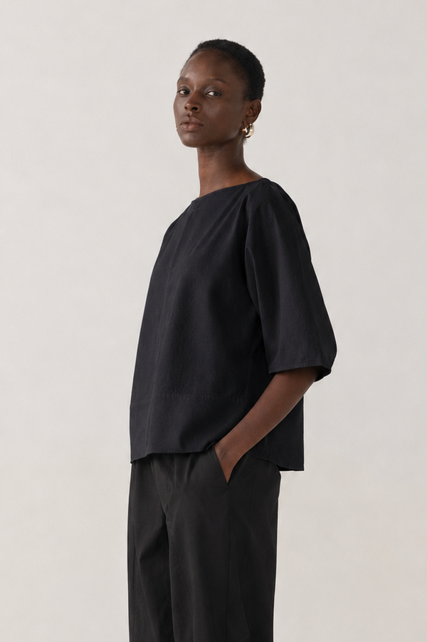 Person wearing a black outfit on a white background