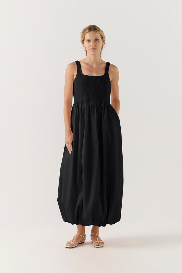 Woman wearing a black sleeveless dress on a white background