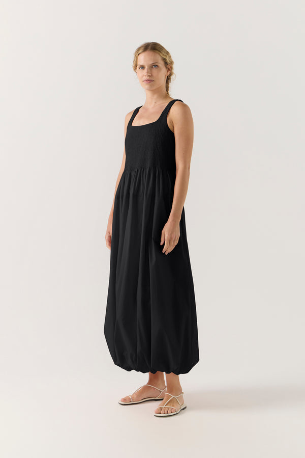 Woman wearing a black sleeveless dress on a white background