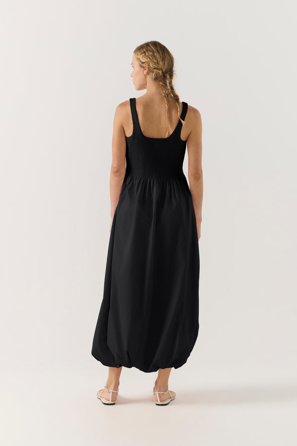 Woman wearing a black sleeveless dress on a white background