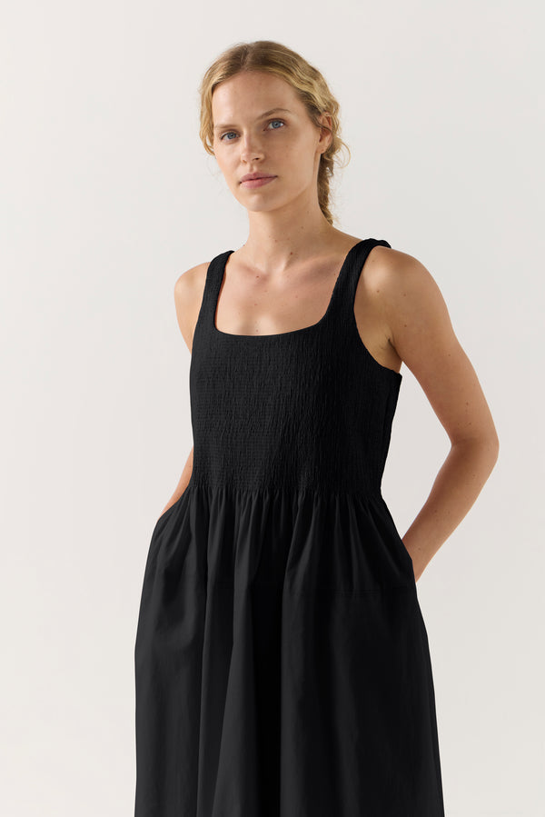 Woman wearing a black sleeveless dress on a white background
