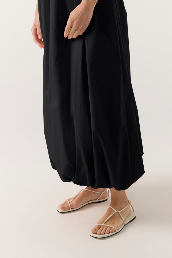 Woman wearing a black sleeveless dress on a white background