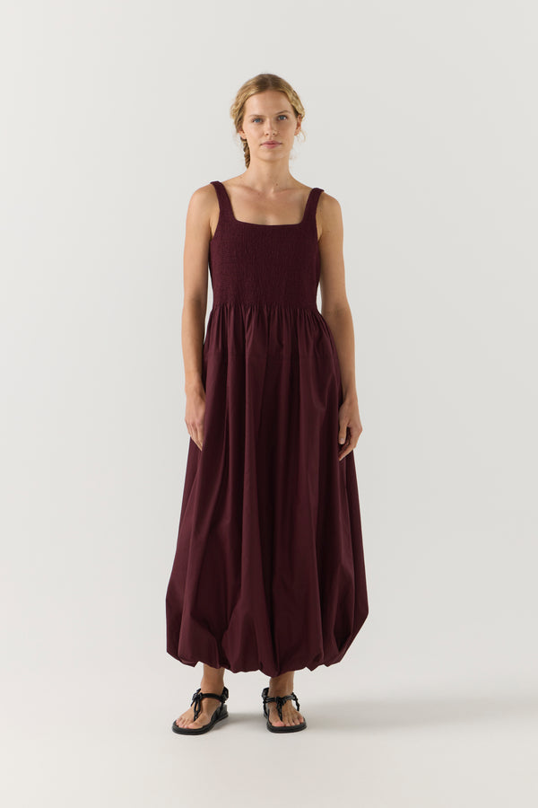 Woman wearing a burgundy dress on a white background