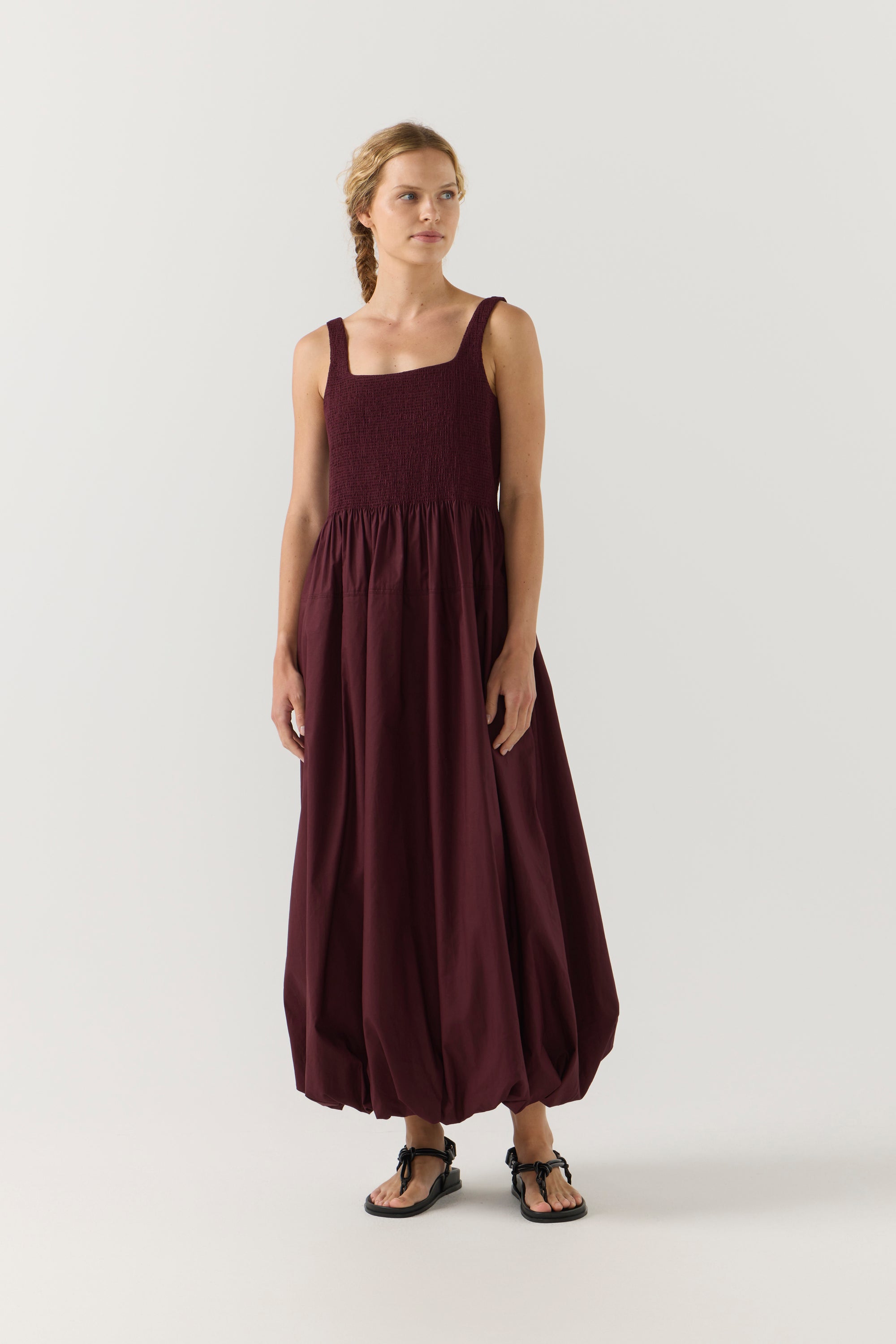 Woman wearing a burgundy dress on a white background