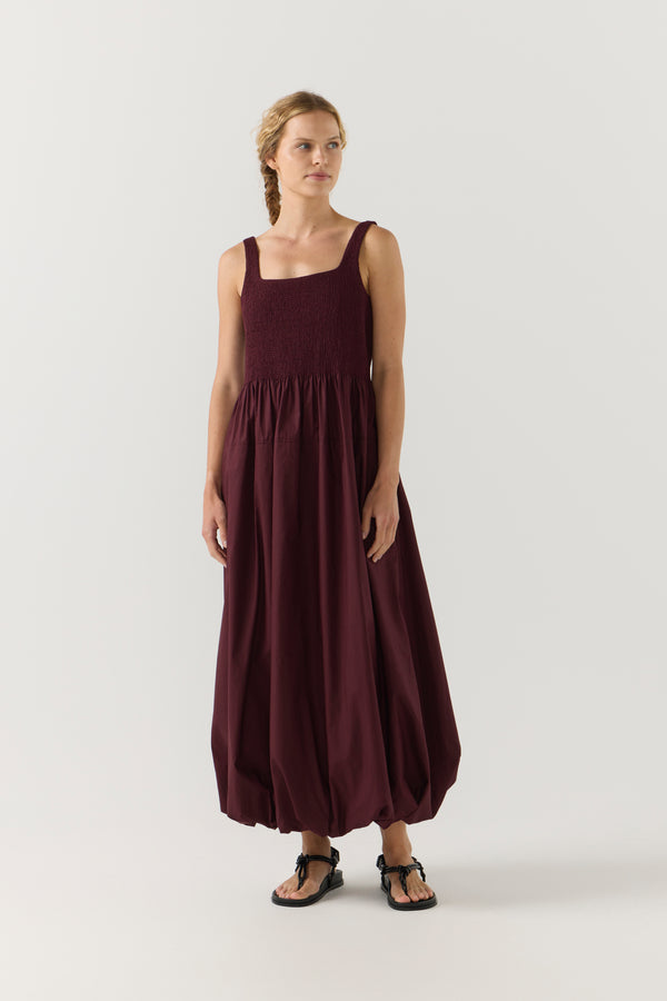 Woman wearing a burgundy dress on a white background
