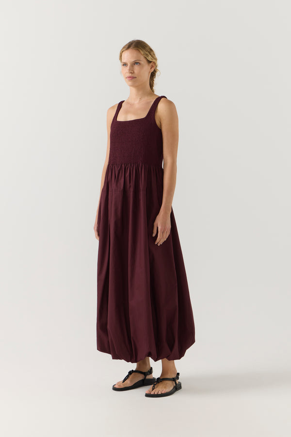 Woman wearing a burgundy dress on a white background