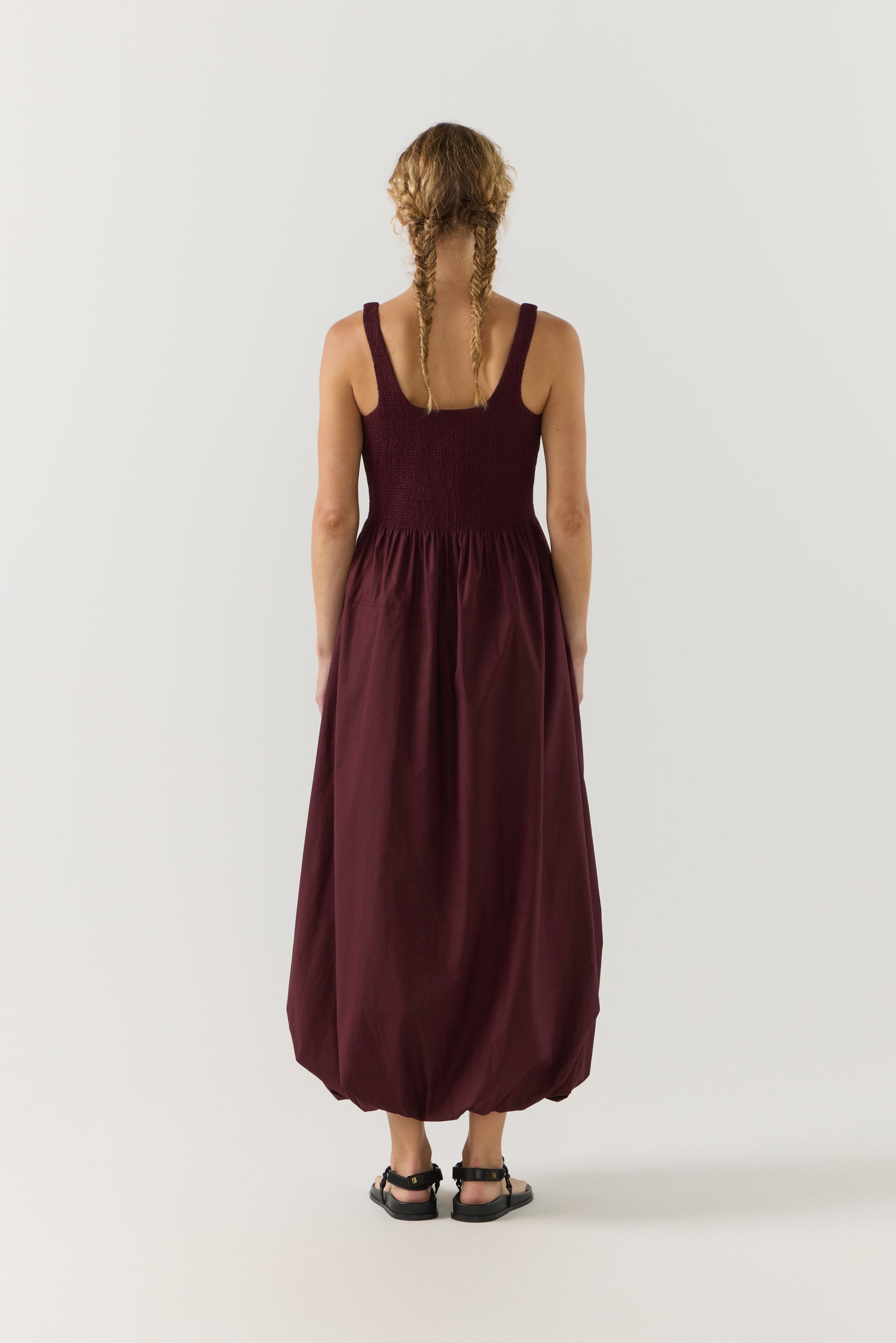 Woman wearing a burgundy dress on a white background