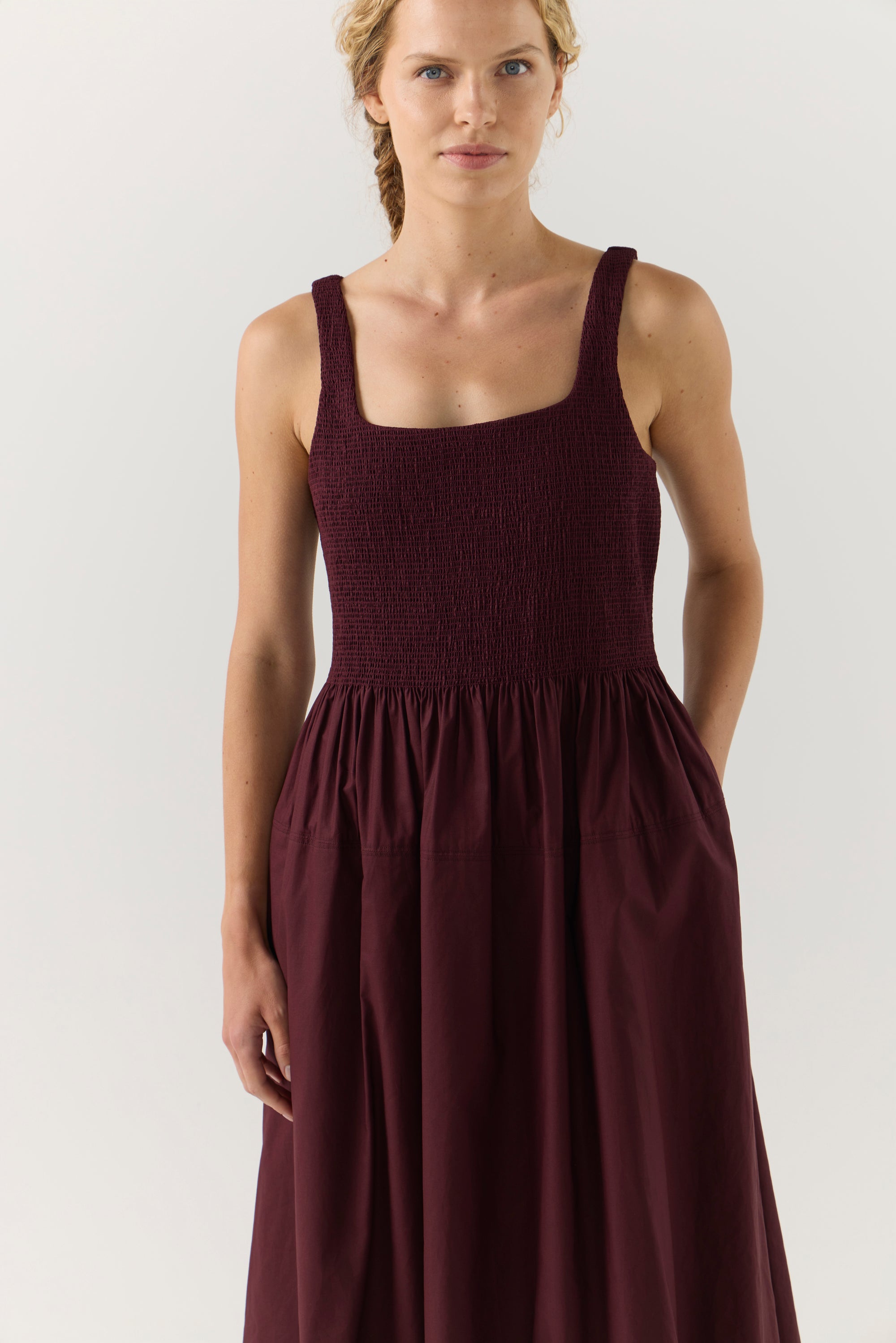 Woman wearing a burgundy dress on a white background