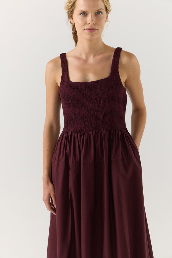 Woman wearing a burgundy dress on a white background