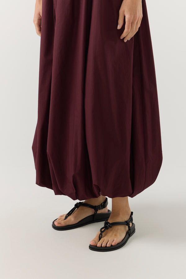 Woman wearing a burgundy dress on a white background