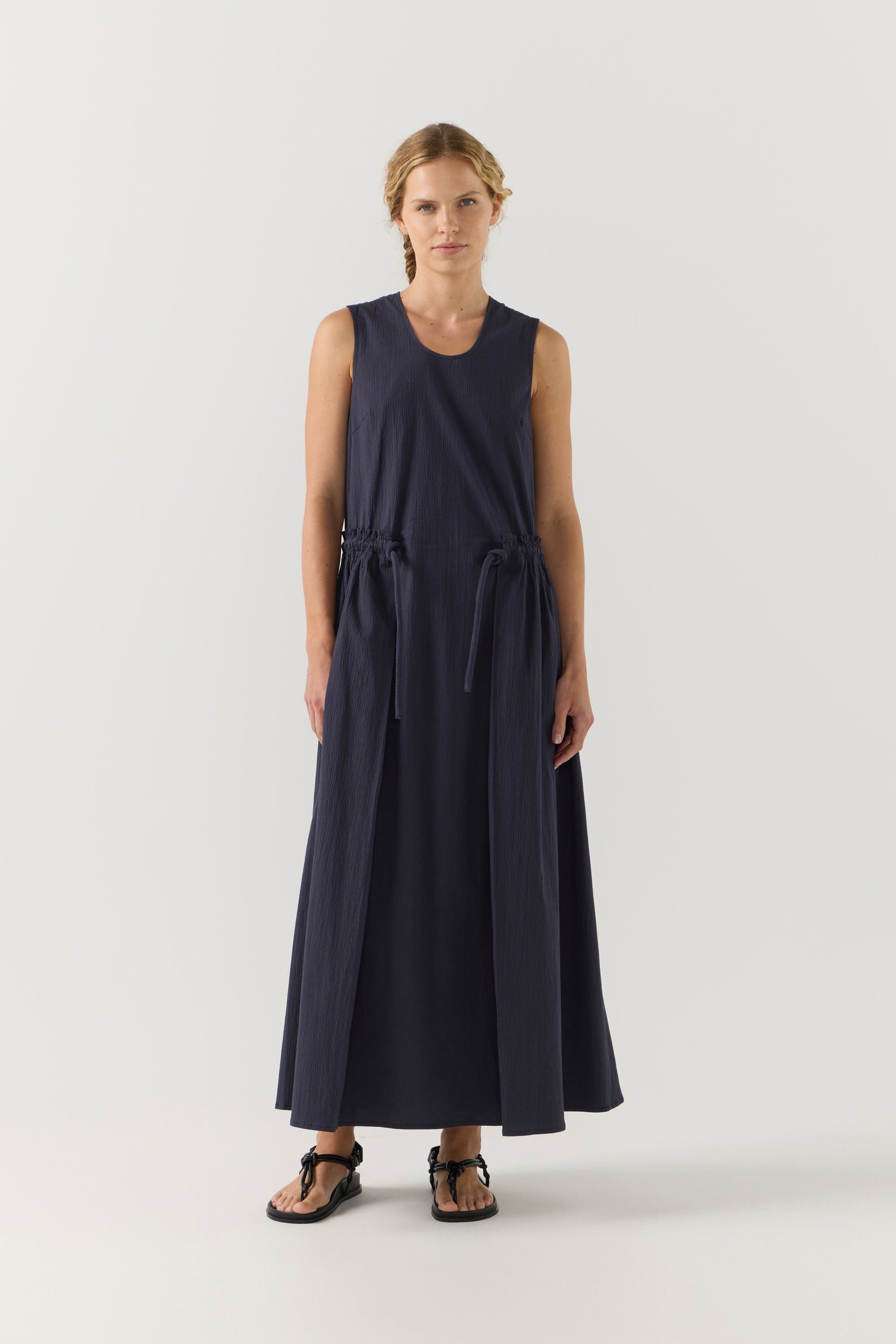 Woman wearing a long dark blue dress on a white background