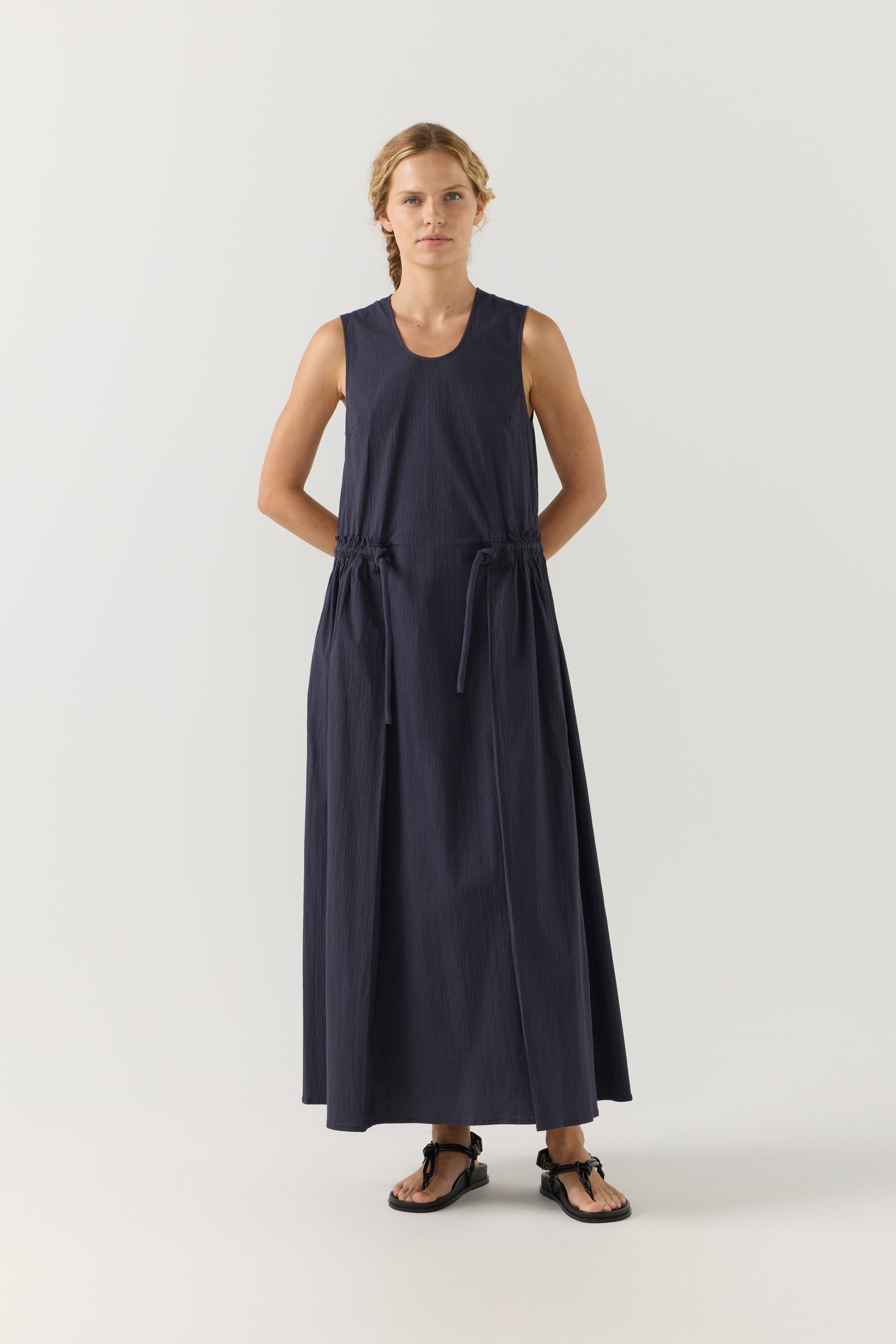 Woman wearing a long dark blue dress on a white background