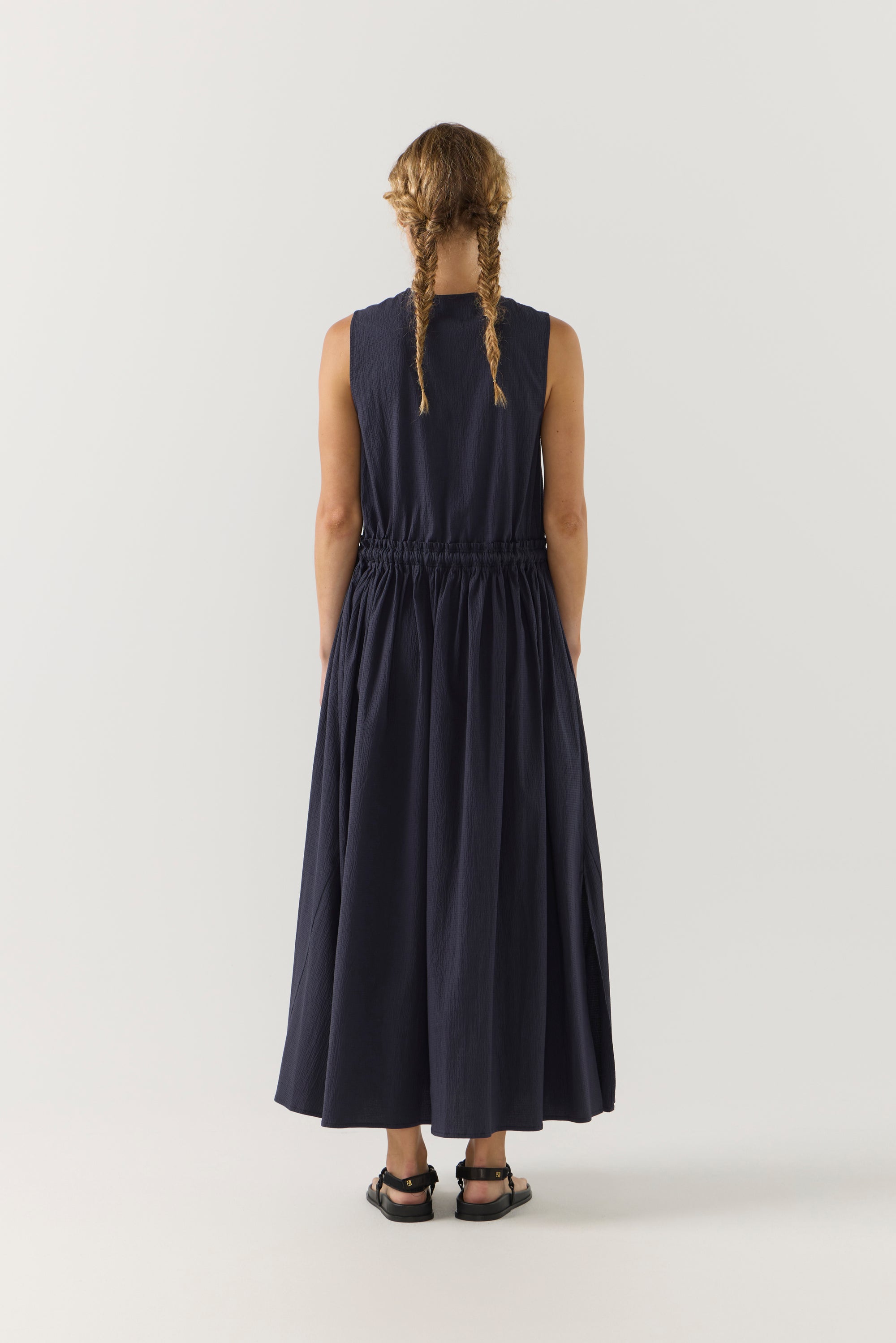 Person wearing a long dark blue dress on a white background