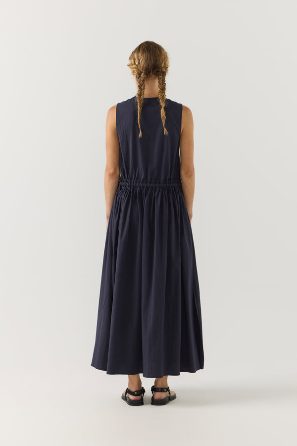 Person wearing a long dark blue dress on a white background
