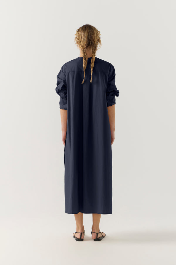 Woman wearing a dark blue dress on a white background
