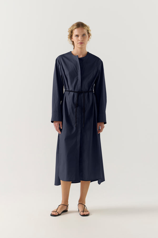 Woman wearing a dark blue dress on a white background