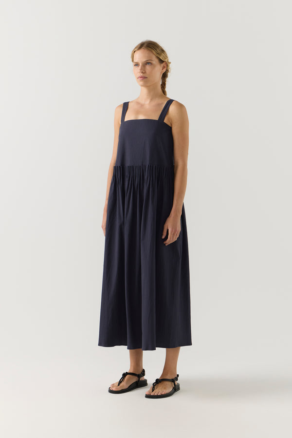 Woman wearing a navy blue dress on a white background