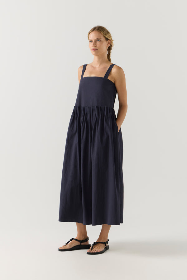 Woman wearing a navy blue dress on a white background