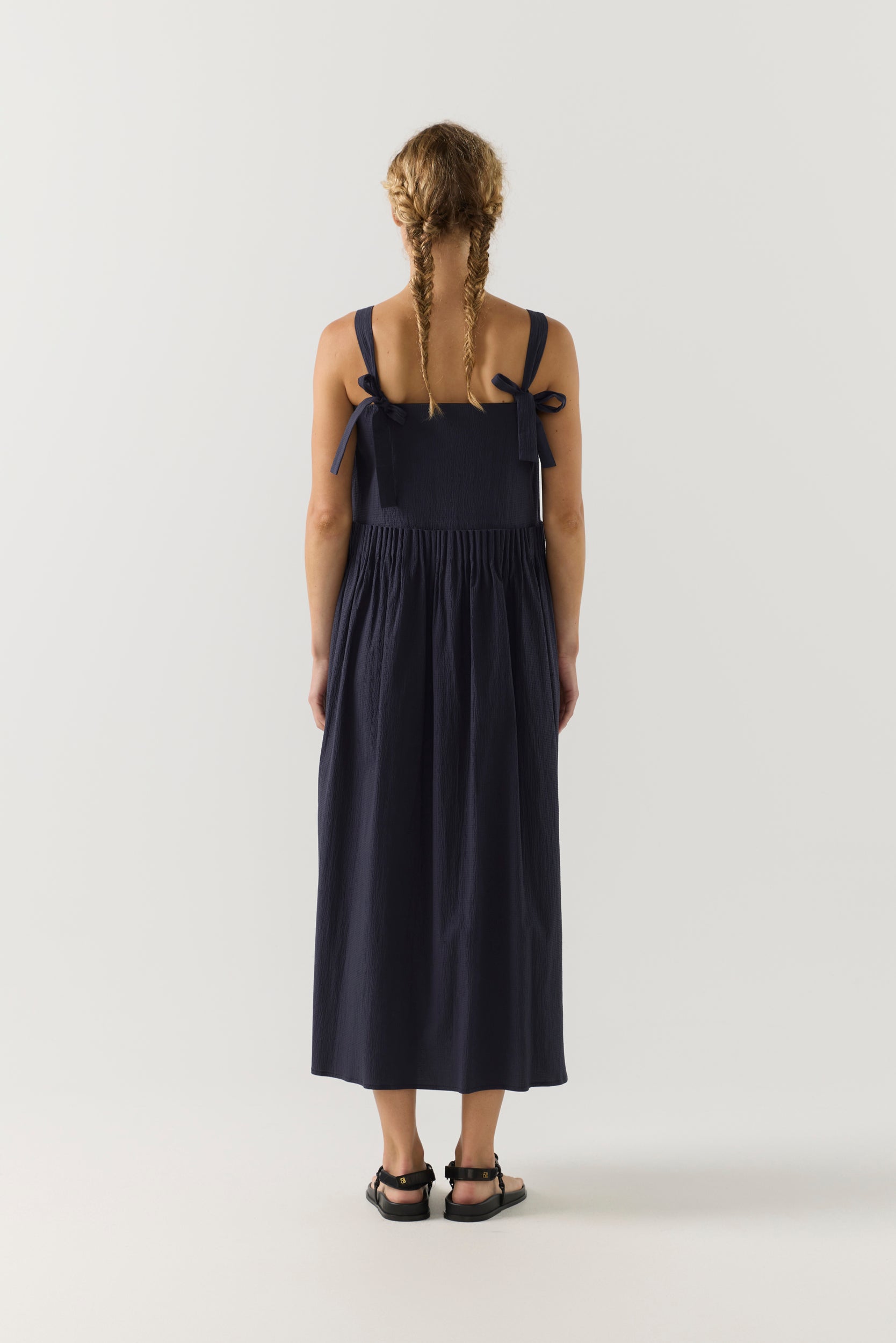 Woman wearing a navy blue dress on a white background