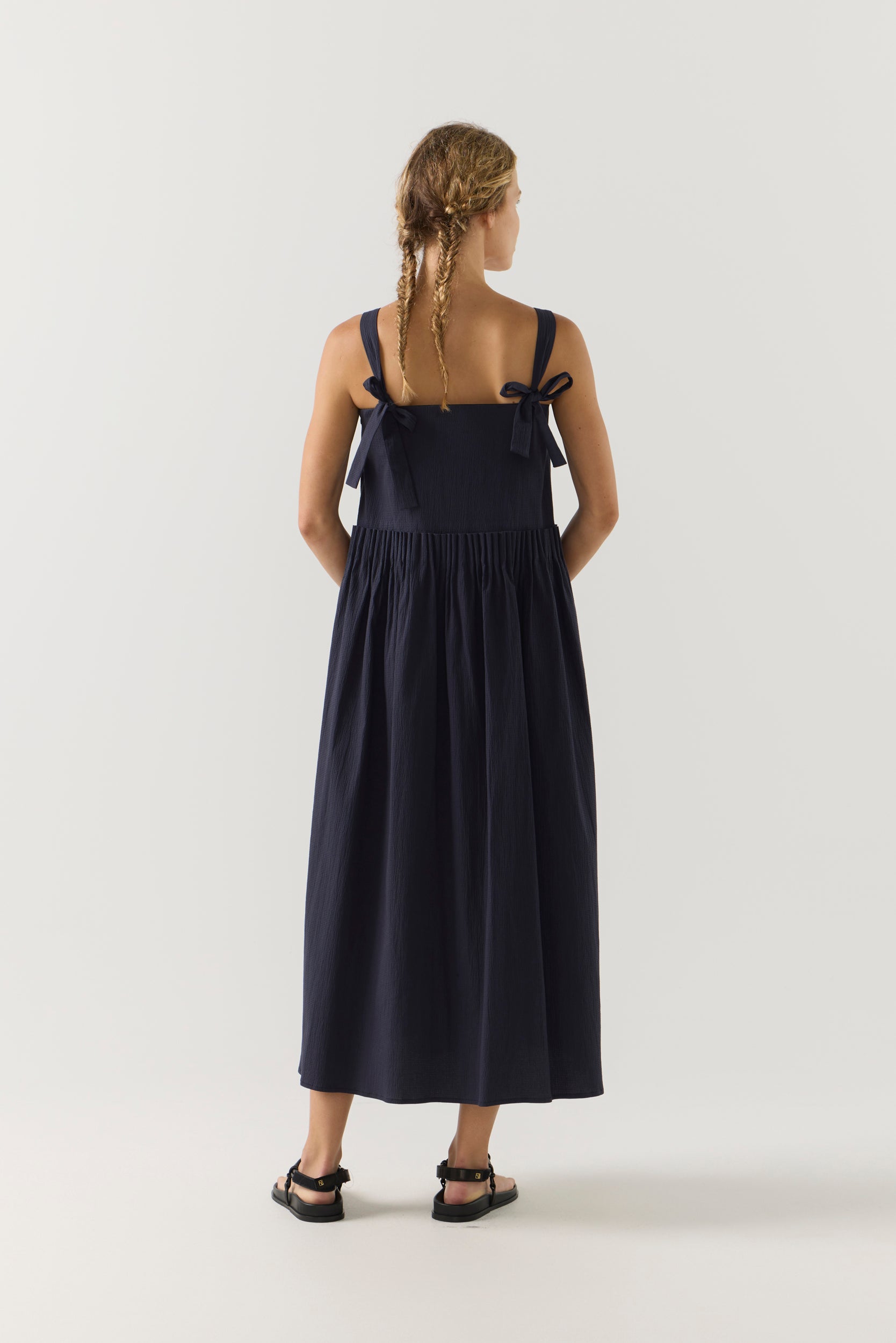 Woman wearing a navy blue dress on a white background