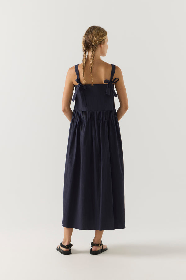 Woman wearing a navy blue dress on a white background