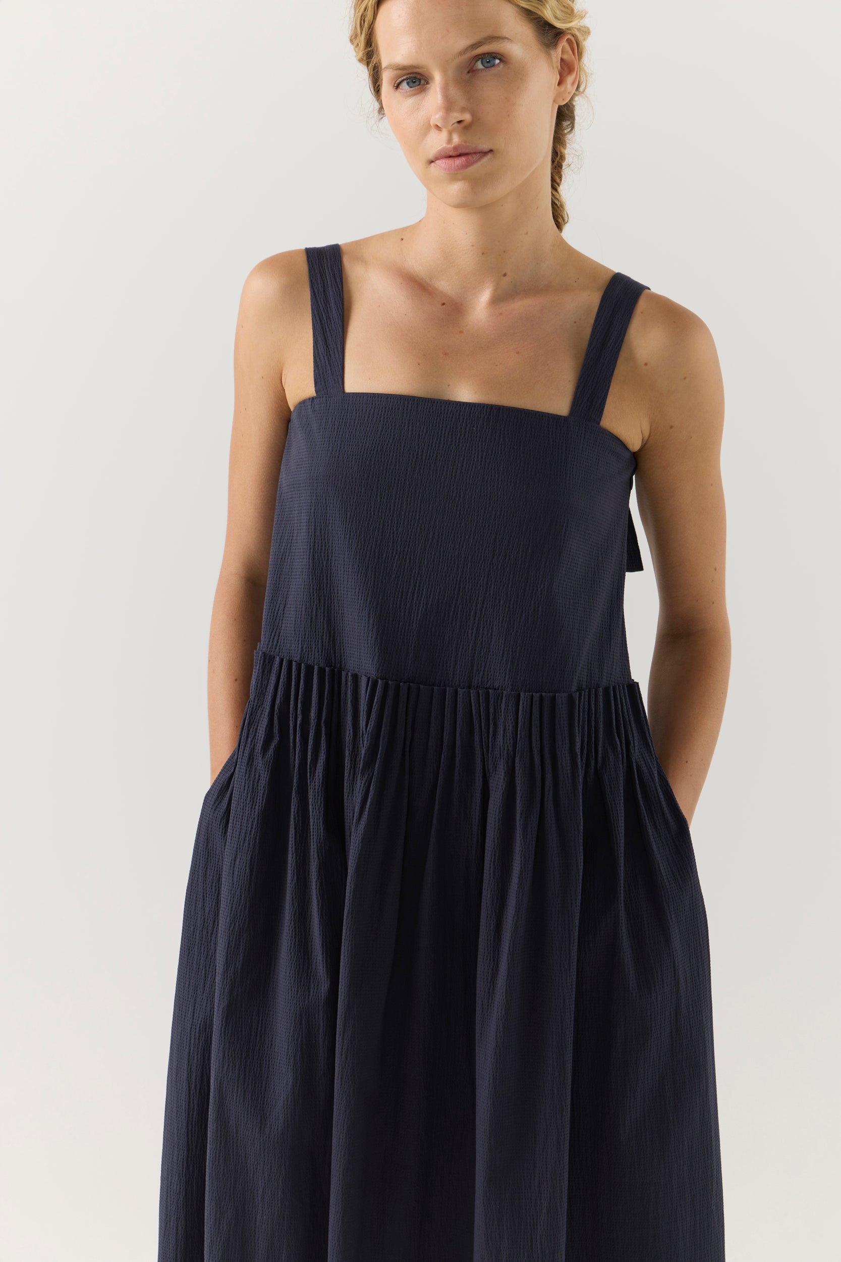 Woman wearing a navy blue dress on a white background