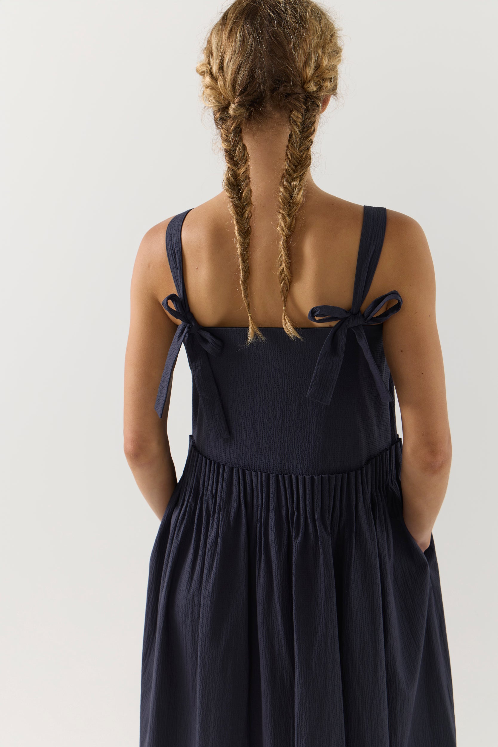 Woman wearing a navy blue dress on a white background