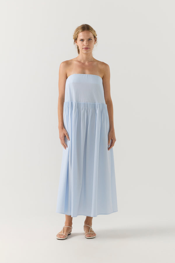 Woman wearing a strapless white dress on a plain background