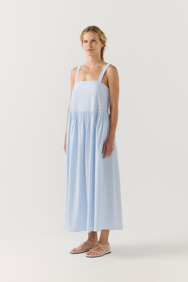 Woman wearing a light blue dress on a white background