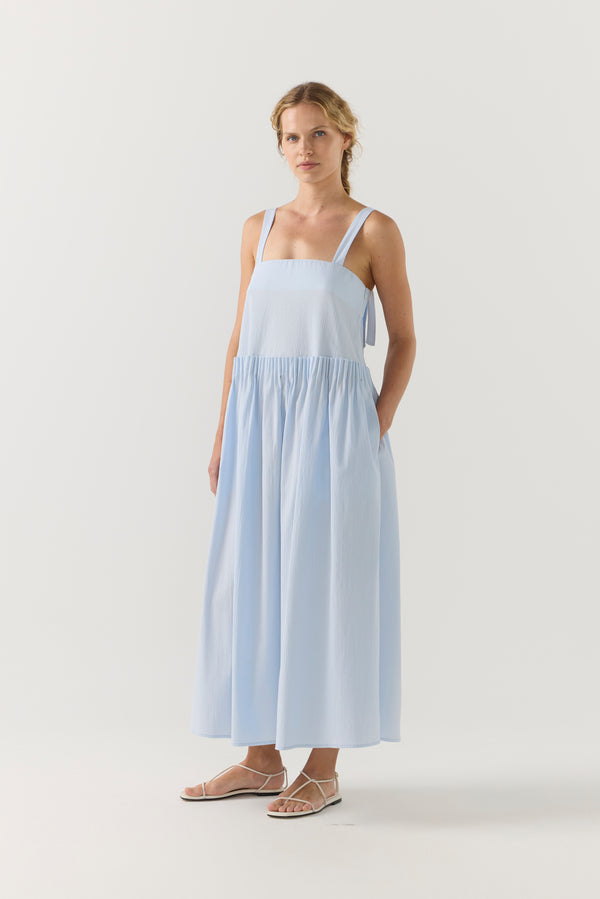 Woman wearing a light blue dress on a white background