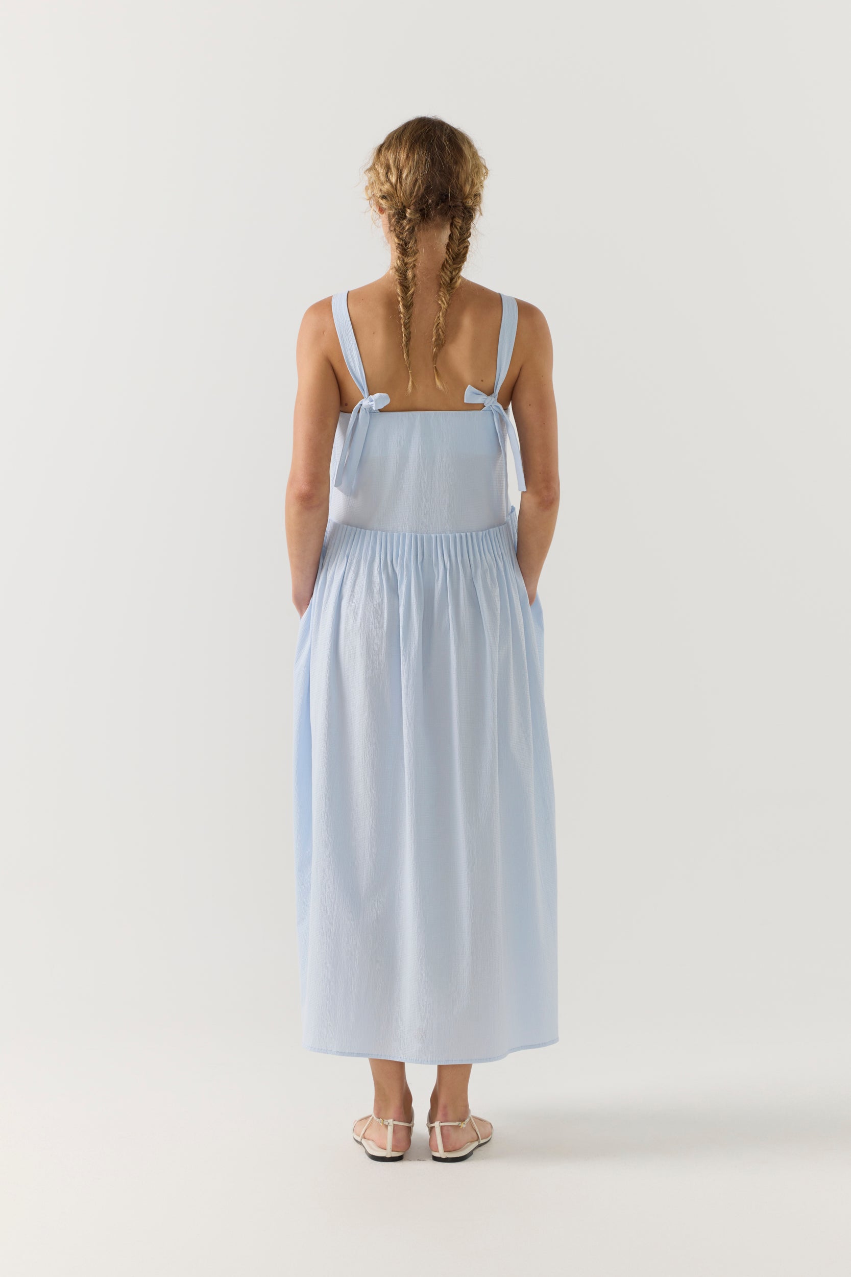 Woman wearing a light blue dress on a white background