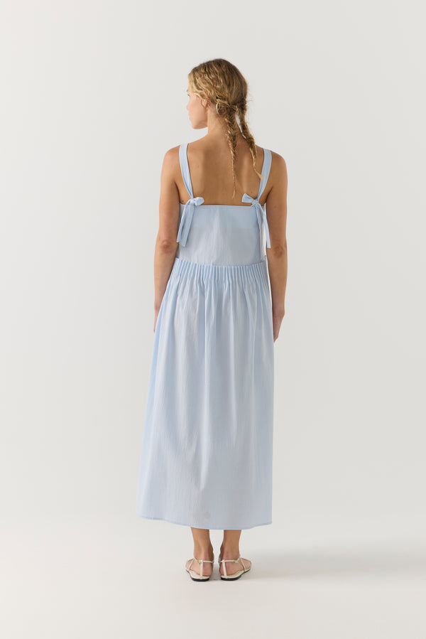Woman wearing a light blue dress on a white background