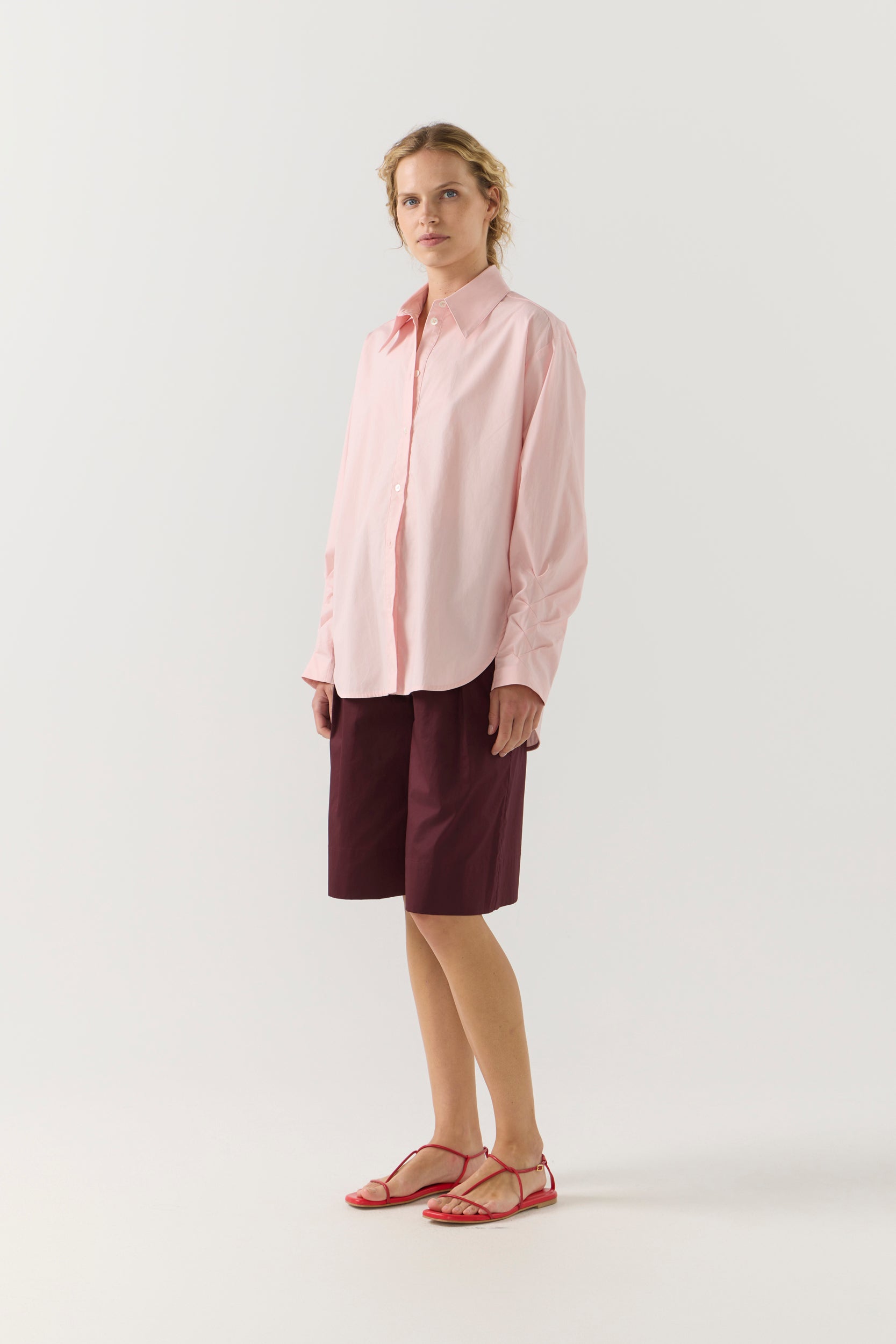 Woman wearing a light pink shirt against a plain background