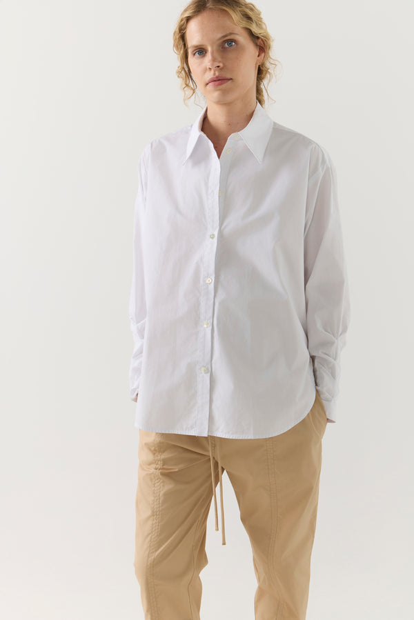 Person wearing a white shirt and beige pants on a white background