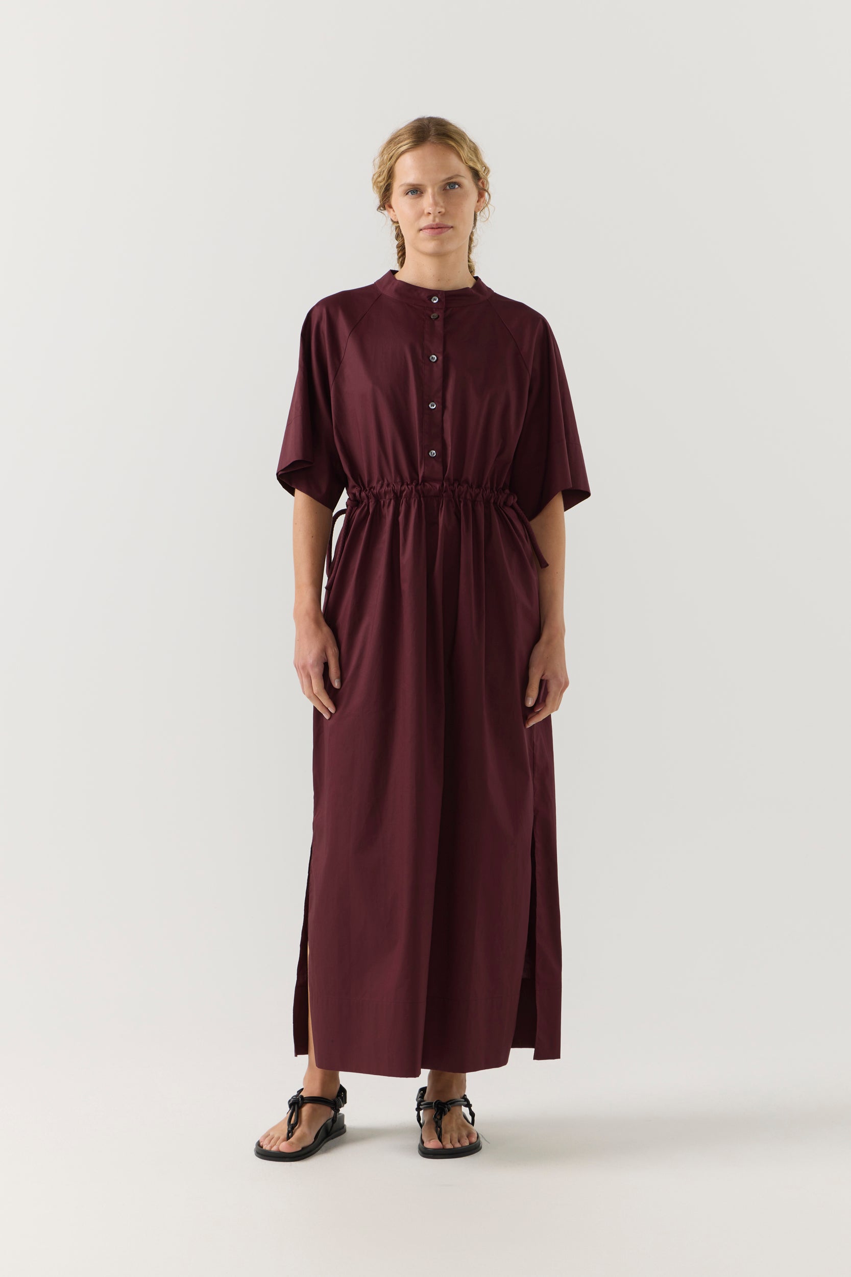 Woman wearing a burgundy dress on a white background