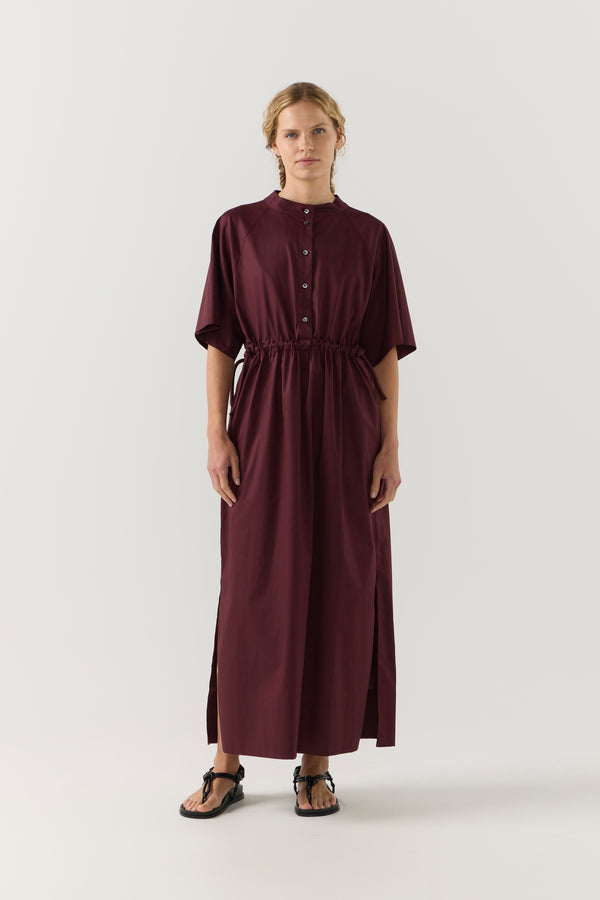 Woman wearing a burgundy dress on a white background