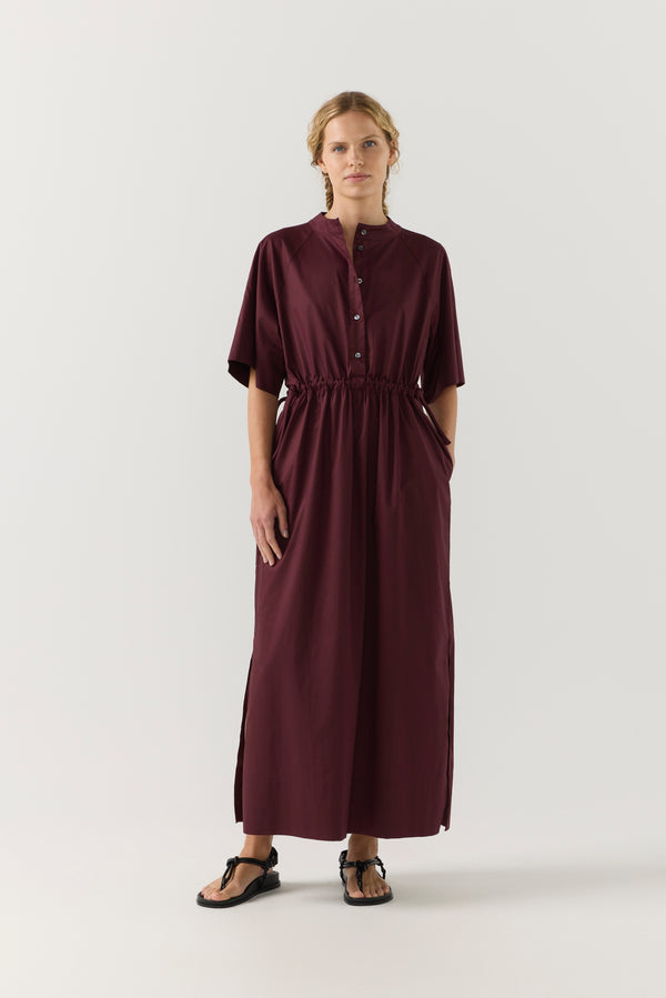 Woman wearing a burgundy dress on a white background