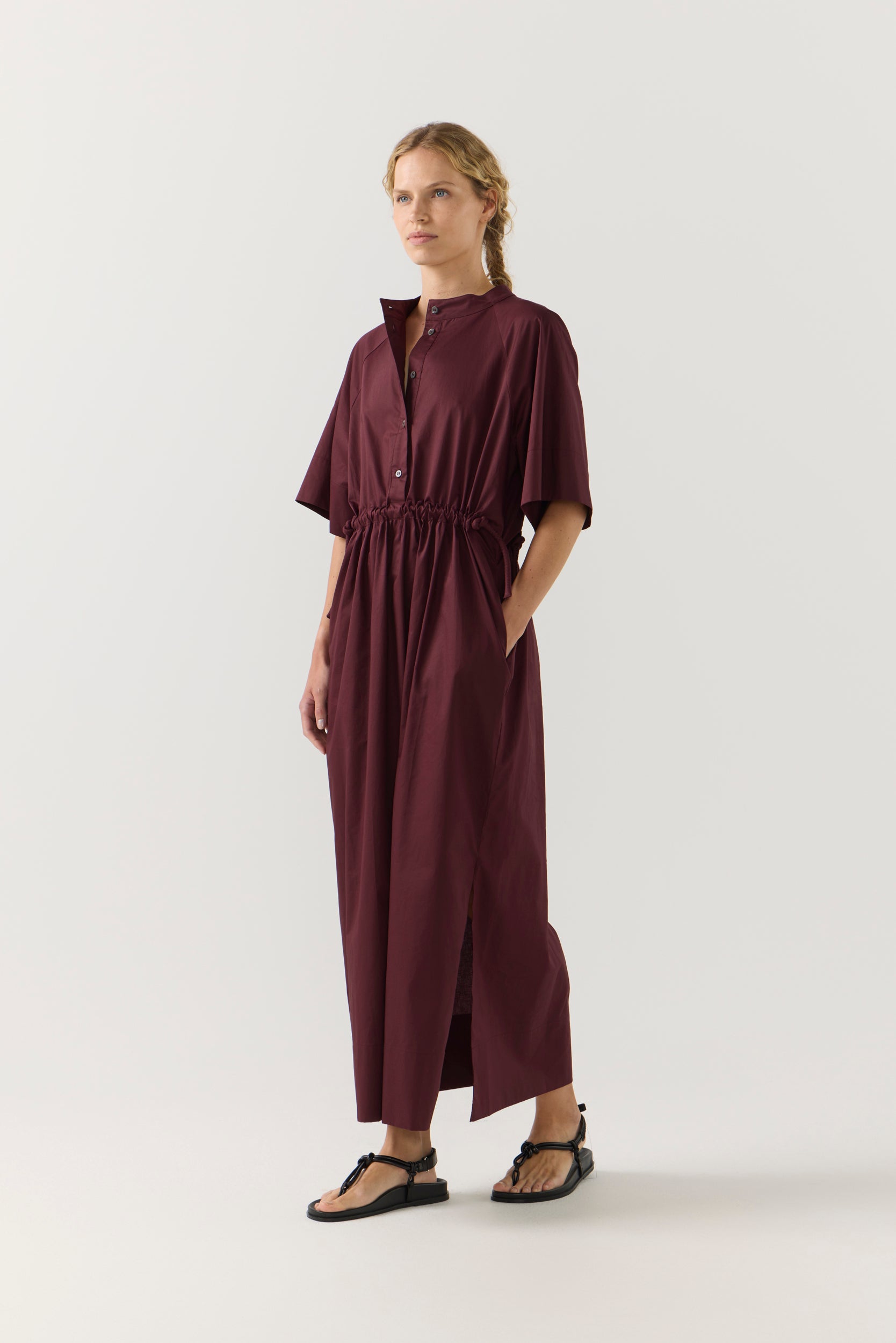 Woman wearing a burgundy dress on a white background