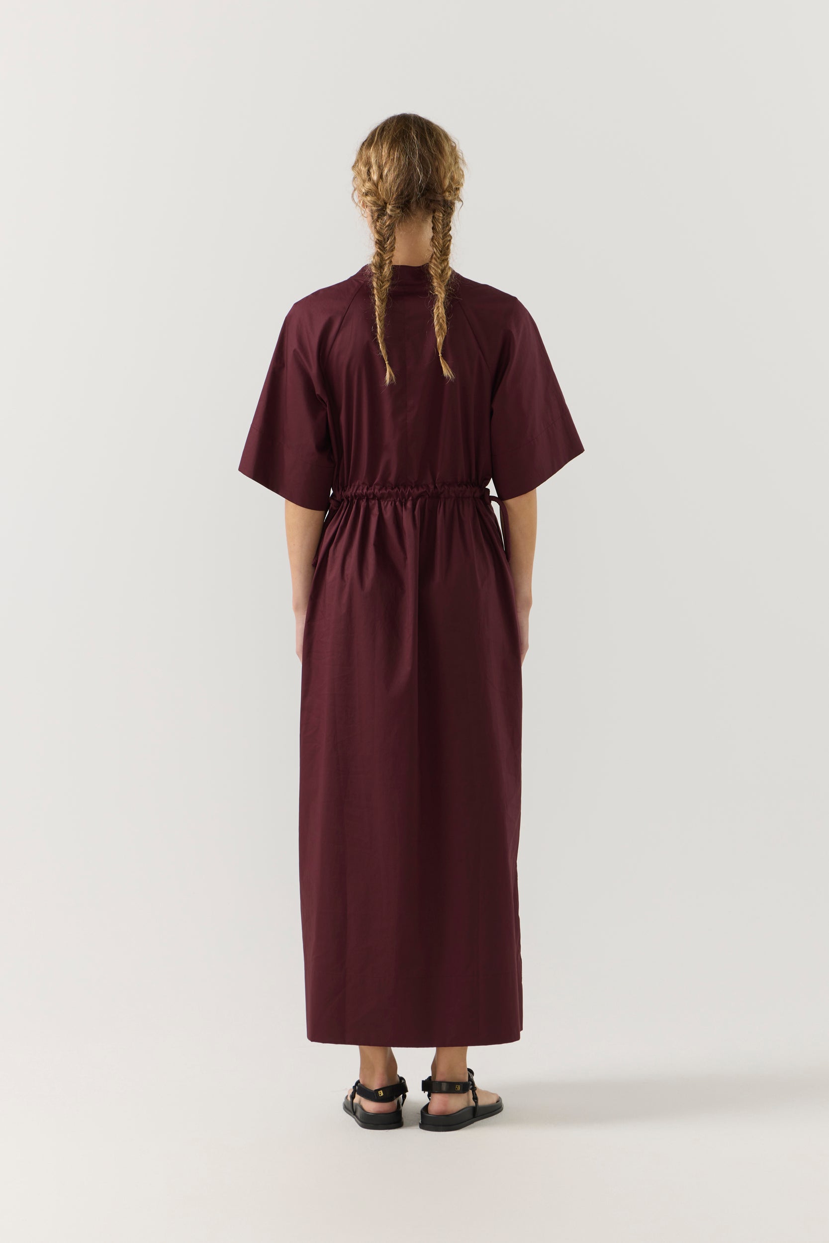 Woman wearing a burgundy dress on a white background