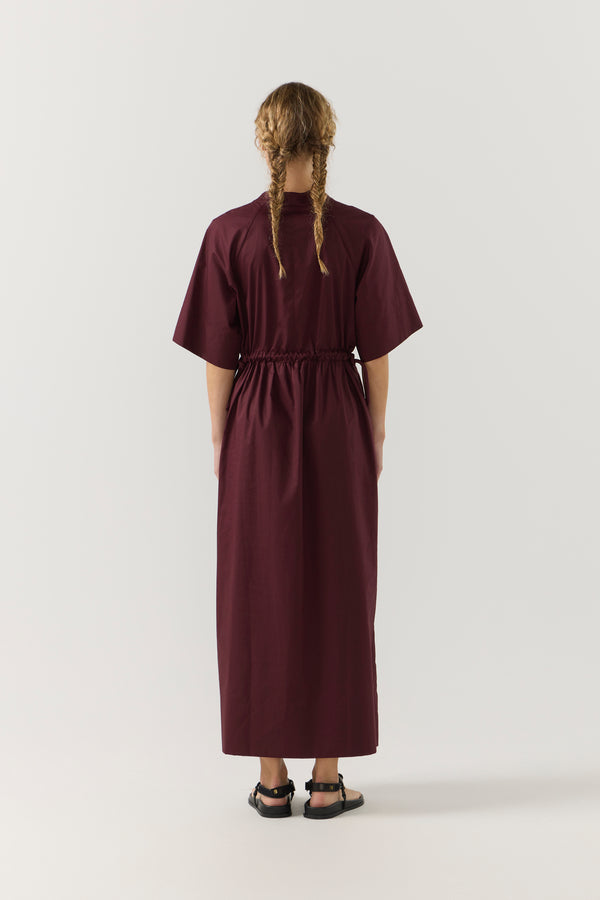 Woman wearing a burgundy dress on a white background