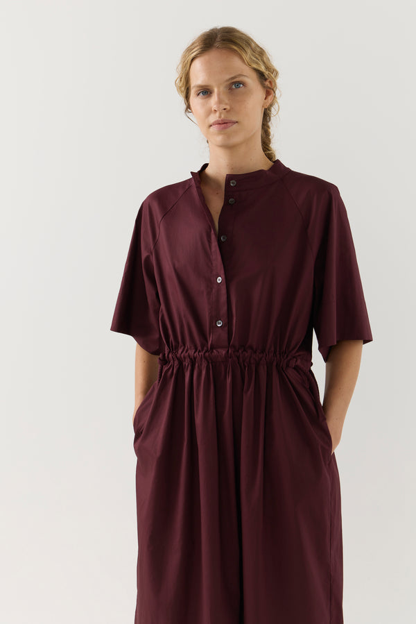 Woman wearing a burgundy dress on a white background