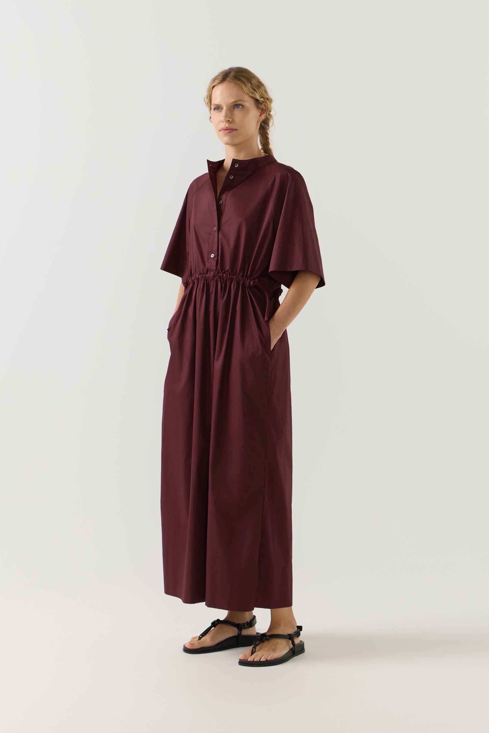 Woman wearing a burgundy dress on a white background