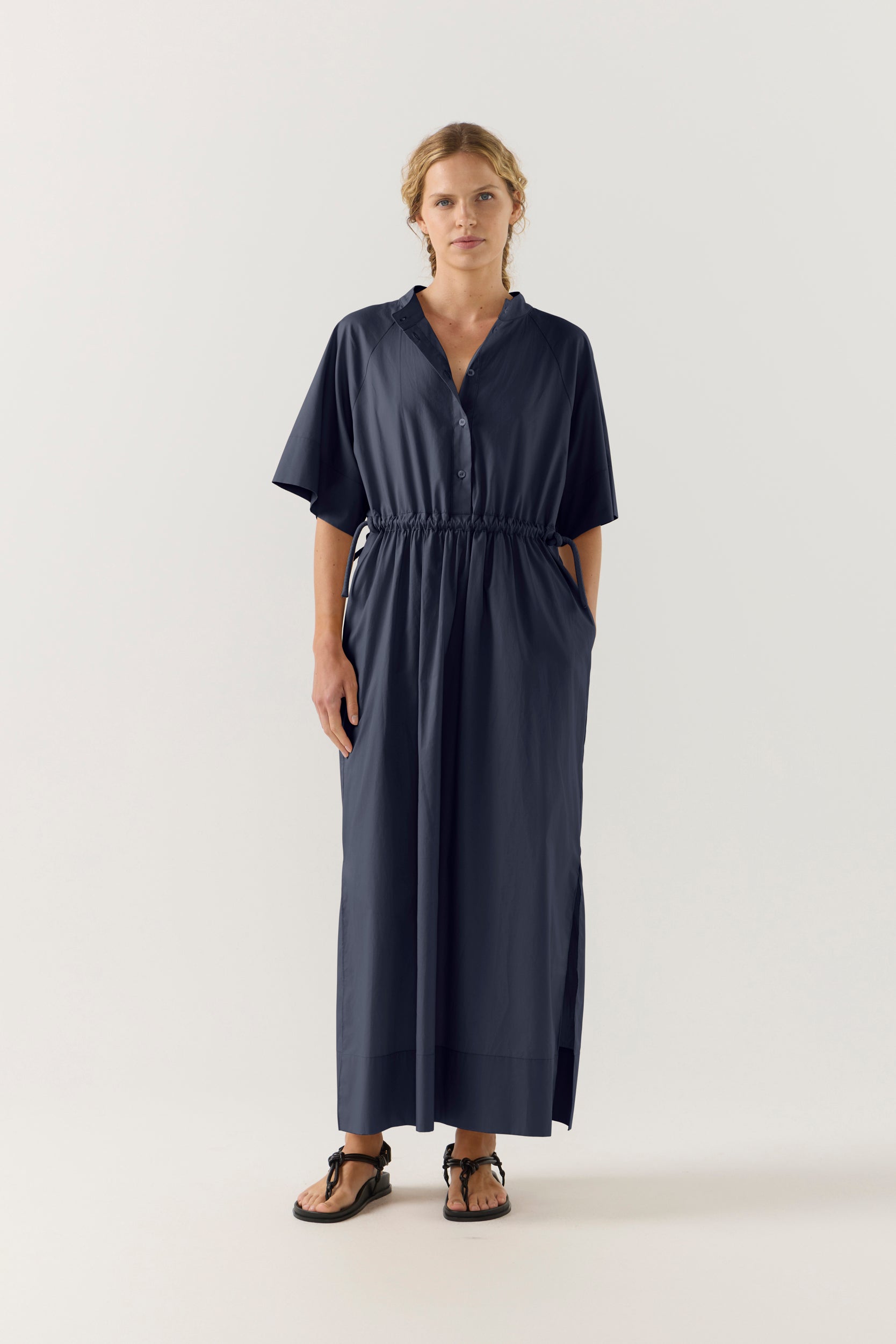 Woman wearing a dark blue dress with a white background