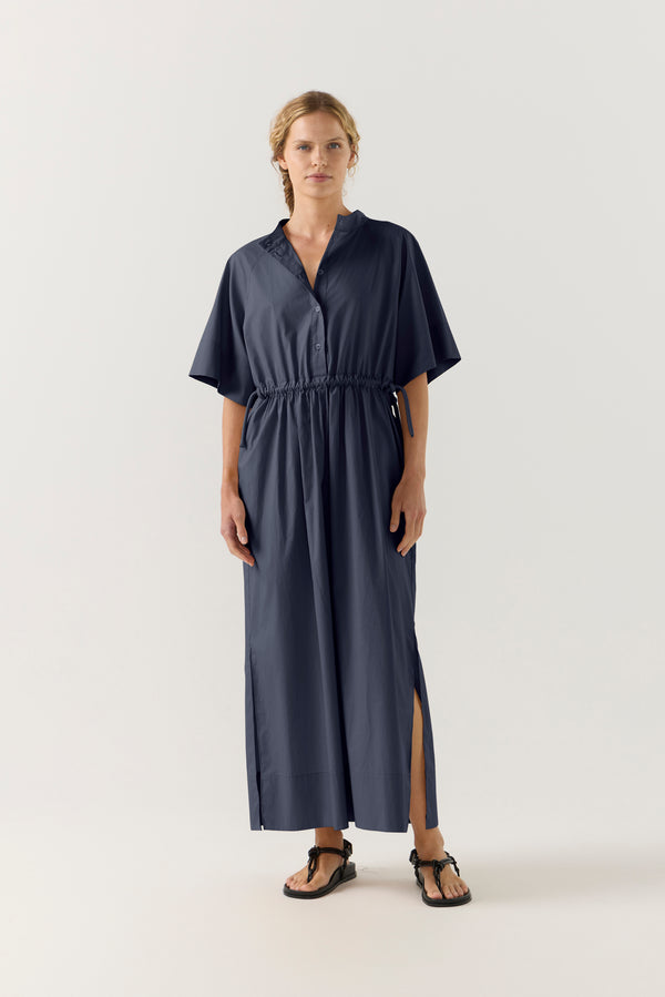 Woman wearing a dark blue dress with a white background