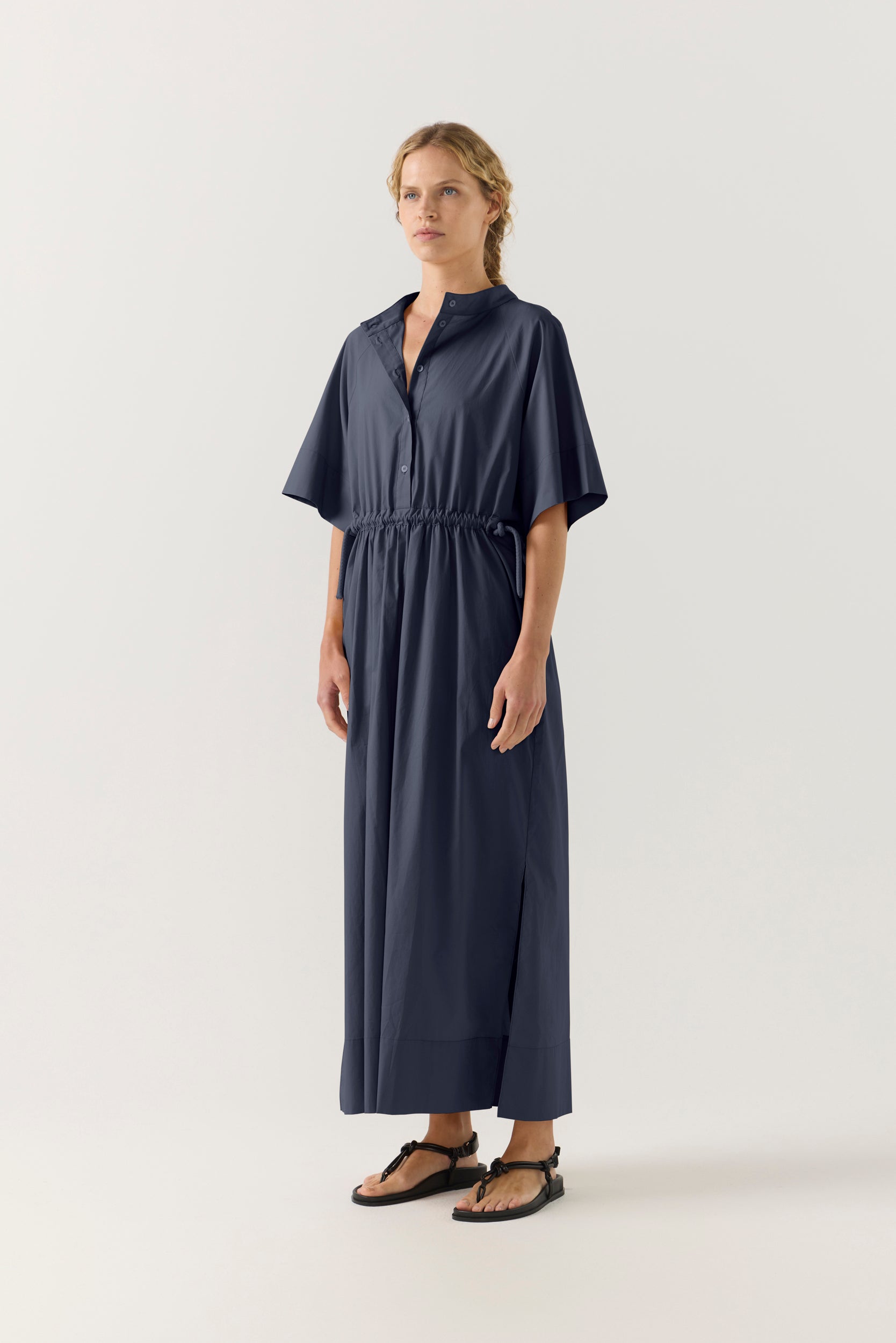 Woman wearing a dark blue dress with a white background