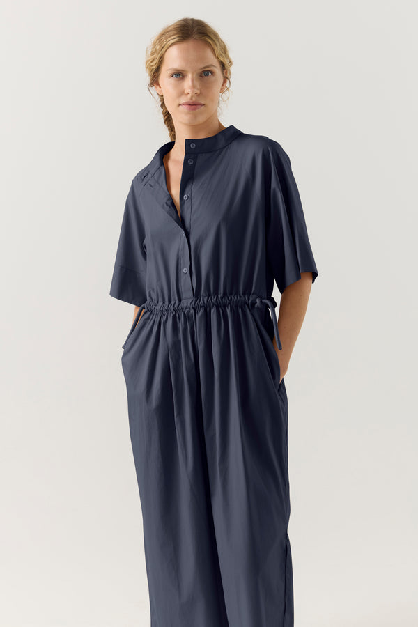 Woman wearing a dark blue dress with a white background