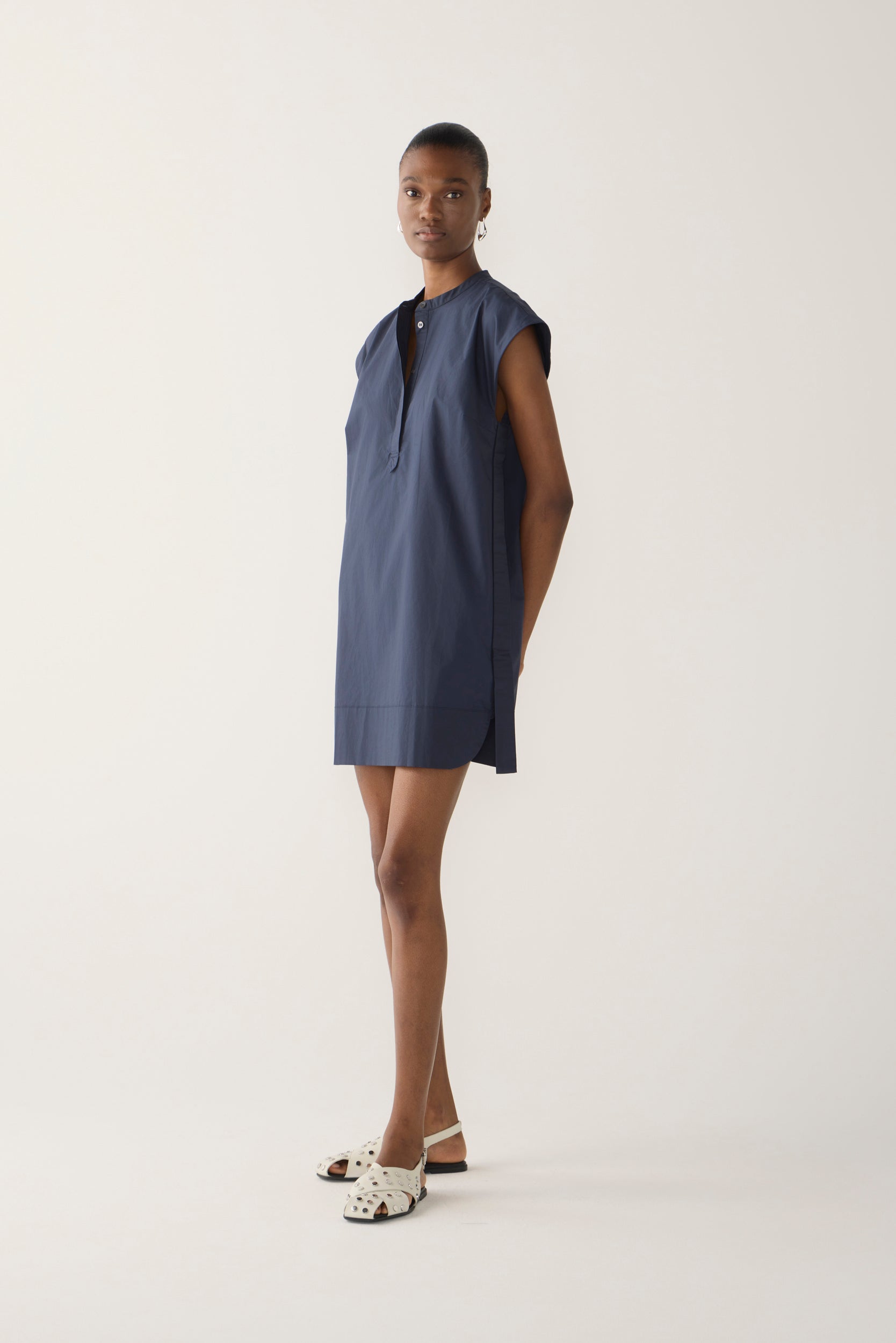 Woman wearing a navy blue dress on a white background