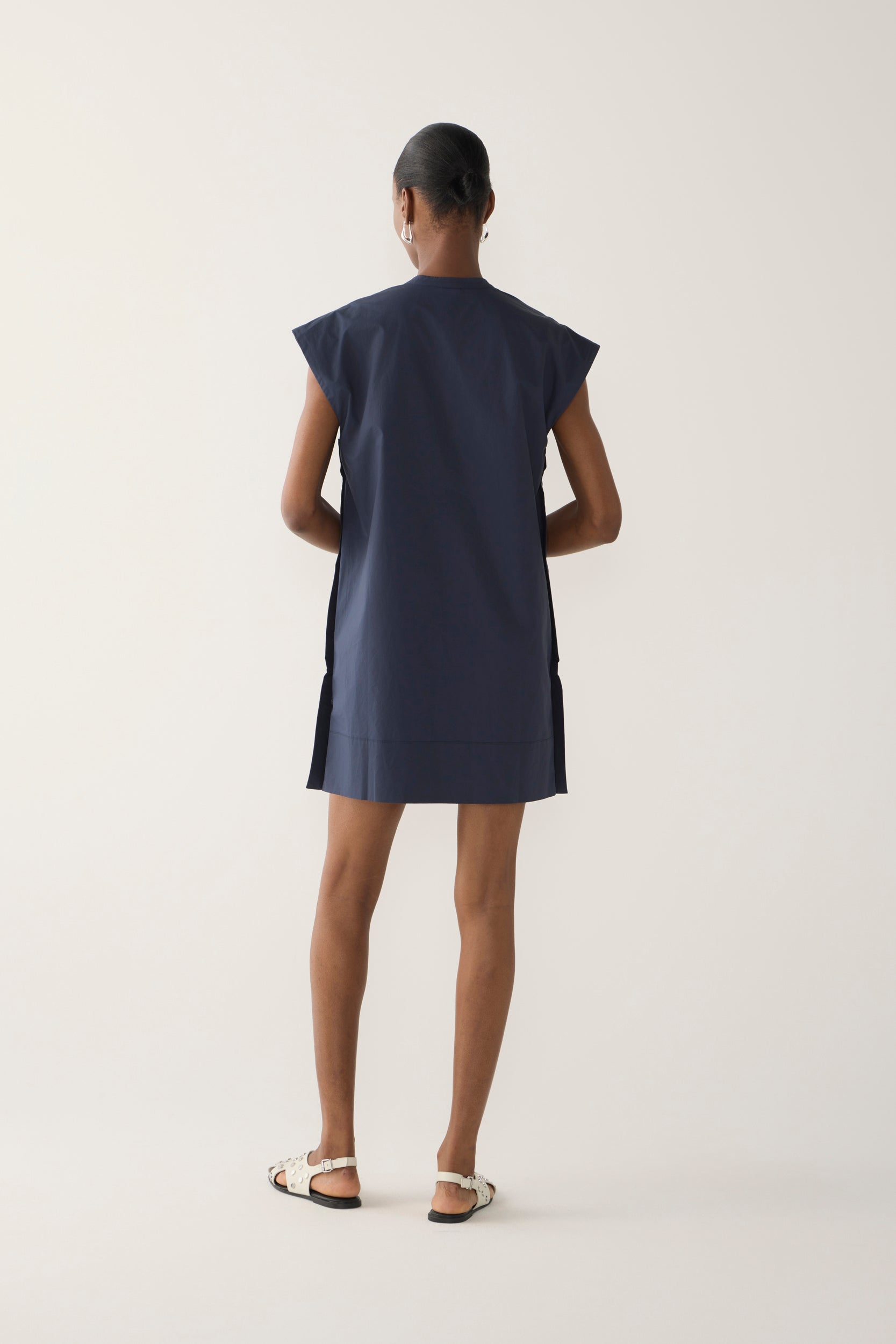 Woman wearing a navy blue dress on a white background