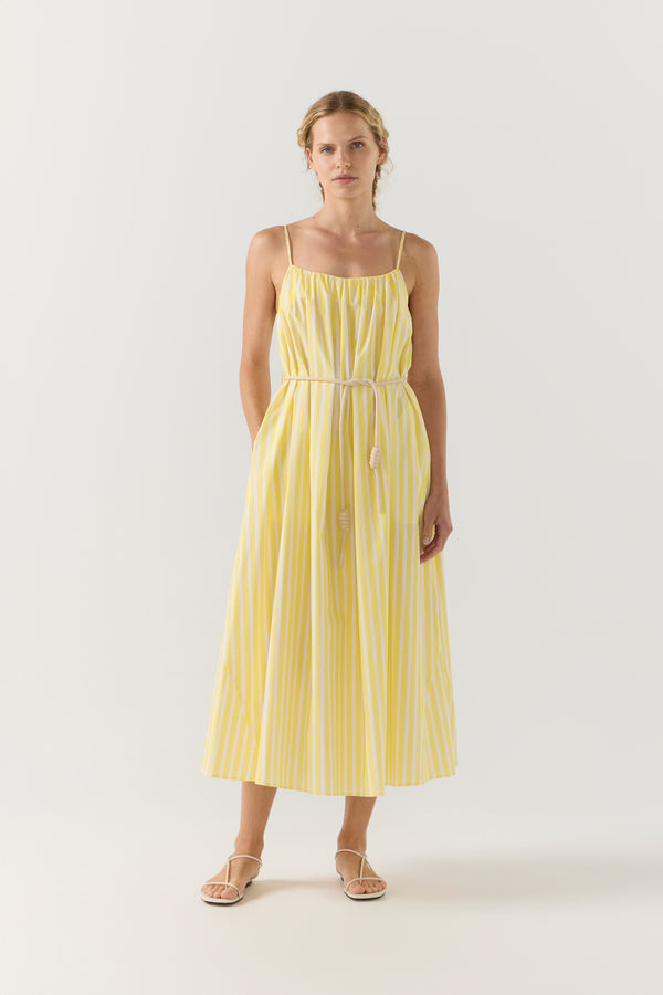 Woman wearing a yellow striped dress on a white background