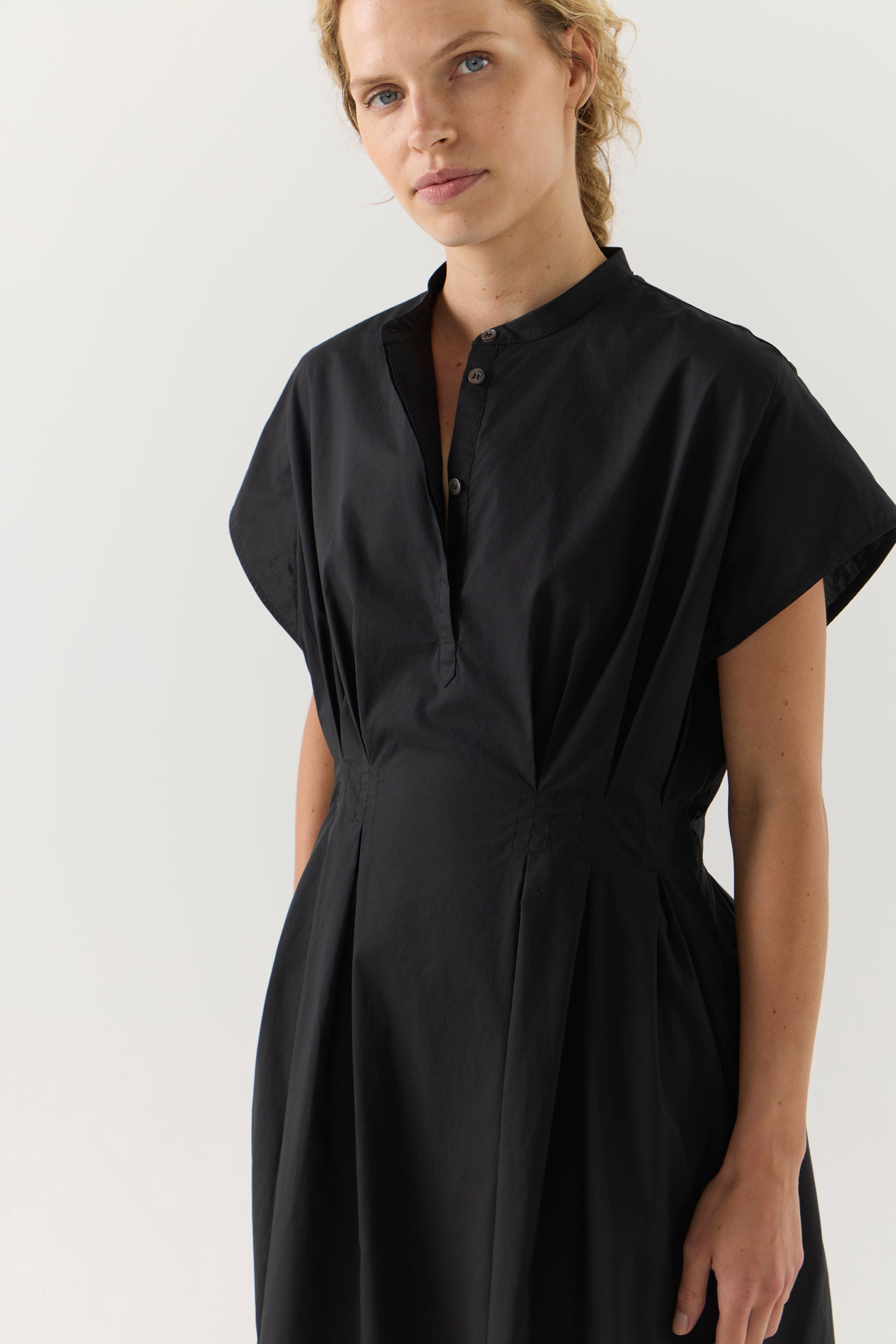 Woman wearing a black dress on a white background